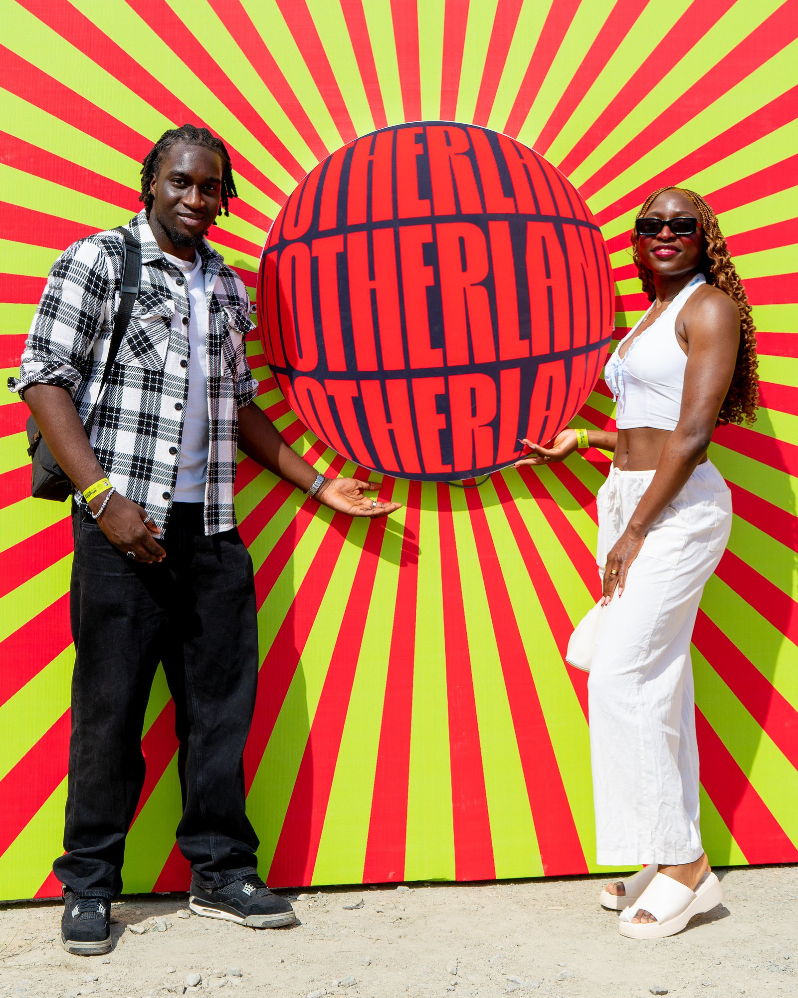 A guest posing beside the Motherland sunburst artwork
